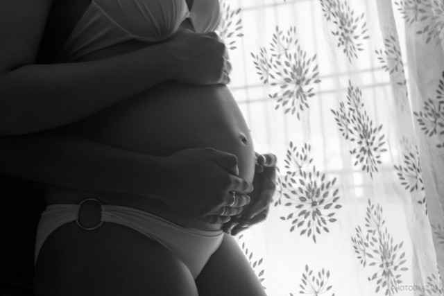Man and woman holding her pregnant belly