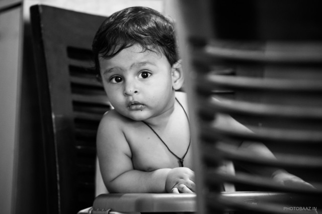 Adorable baby Rishaan sitting on a table looking straight at the camera.