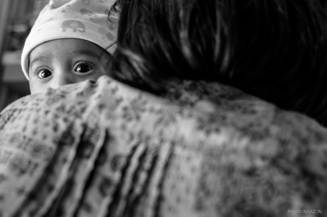 Baby looking over his mother's shoulder